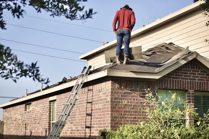 Professional roofer working on a residential roof in Pondville